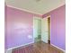 A bedroom with purple walls, wood-look flooring, white trim and an open doorway leading to another room at 328 Fox Field Rd, Walterboro, SC 29488