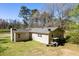 View of the rear of the home, showing roof, backyard, and lush greenery at 328 Fox Field Rd, Walterboro, SC 29488