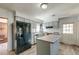 Well-lit kitchen with wood-look floors, center island, black refrigerator, and traditional cabinets at 328 Fox Field Rd, Walterboro, SC 29488