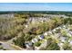 Aerial view of home surrounded by mature trees and a pond in a quiet neighborhood at 329 Carriage Wheel Rd, Moncks Corner, SC 29461
