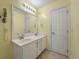 Well-lit bathroom boasts a double vanity with large mirror and white cabinetry at 329 Carriage Wheel Rd, Moncks Corner, SC 29461