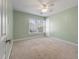 Bright bedroom with a ceiling fan, neutral carpet, and a large window providing ample natural light at 329 Carriage Wheel Rd, Moncks Corner, SC 29461