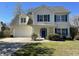 Charming two-story home featuring a two-car garage, manicured lawn, and bright blue shutters at 329 Carriage Wheel Rd, Moncks Corner, SC 29461
