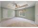 Spacious main bedroom with neutral carpeting, tray ceiling, and a window providing natural light at 329 Carriage Wheel Rd, Moncks Corner, SC 29461