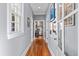 Hallway with hardwood floors, neutral walls, and decor that leads to the kitchen area, showcasing the home's layout at 382 Race St # A, Charleston, SC 29403