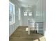 Bright hallway features modern railing, wood floors, natural light, and shiplap accent wall at 3889 Summerton St, Mount Pleasant, SC 29466