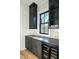 Custom kitchen featuring dark cabinetry, sleek countertops, mosaic backsplash, and a built-in wine cooler at 3889 Summerton St, Mount Pleasant, SC 29466