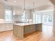 Modern kitchen boasting a central island, custom light fixtures, and white cabinets at 3889 Summerton St, Mount Pleasant, SC 29466