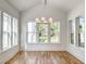 Bright room with modern chandelier, wood floors, vaulted ceilings, and multiple windows at 3889 Summerton St, Mount Pleasant, SC 29466