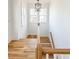 Well-lit staircase featuring hardwood stairs, white risers, and a modern chandelier at 3889 Summerton St, Mount Pleasant, SC 29466