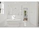 Bright bathroom boasts a soaking tub, glass-enclosed shower, marble floors, and plenty of natural light at 3893 Summerton St, Mount Pleasant, SC 29466