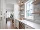 Bright kitchen area with bar, wine fridge, white cabinets, stone backsplash and floating shelves at 3893 Summerton St, Mount Pleasant, SC 29466