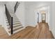 A staircase features wood treads, a black metal railing, and white risers, with an entryway and chandelier in the background at 3893 Summerton St, Mount Pleasant, SC 29466