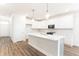 Bright kitchen features white cabinets, stainless steel appliances, a large island and modern pendant lighting at 468 Cadbury Loop, Summerville, SC 29486