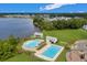 Overhead view of a neighborhood pool and splashpad with lounge chairs, near a lake with surrounding homes at 546 Alderly Dr, Moncks Corner, SC 29461