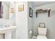 Charming half-bathroom features a pedestal sink, decorative mirror, and a whimsical sign above the toilet at 587 Crossland Dr, Moncks Corner, SC 29461