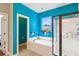 Bright bathroom featuring a soaking tub, walk-in shower, and vibrant blue walls, creating a spa-like ambiance at 587 Crossland Dr, Moncks Corner, SC 29461