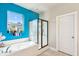 Bright bathroom featuring a soaking tub, separate shower with glass door, and vibrant blue accent wall at 587 Crossland Dr, Moncks Corner, SC 29461