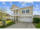 Charming two-story home featuring a double porch, well-maintained lawn, and attached garage at 587 Crossland Dr, Moncks Corner, SC 29461