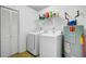 Functional laundry area with a washer, dryer, water heater, and shelving for storage at 679 Kent St, Mount Pleasant, SC 29464