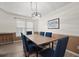 Bright dining room with a large window and a modern chandelier above the table with six chairs at 9080 Delancey Cir, North Charleston, SC 29406