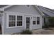 Exterior home view with windows and door leading to a patio area with trees at 9080 Delancey Cir, North Charleston, SC 29406