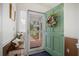 Inviting foyer features a decorative wreath on a green door and a view of the brick walkway outside at 9080 Delancey Cir, North Charleston, SC 29406
