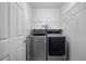 Modern laundry room with stainless steel washer and dryer and wire shelf at 9080 Delancey Cir, North Charleston, SC 29406
