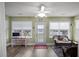 Bright sun room featuring a ceiling fan, windows with white blinds, and access to the backyard at 9080 Delancey Cir, North Charleston, SC 29406