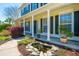 Inviting front porch with decorative landscaping, a charming pond, and white pillars with dark shutters at 9408 Harroway Rd, Summerville, SC 29485