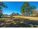 Picturesque golf course view with tall pine trees, manicured fairways, and distant homes at 9408 Harroway Rd, Summerville, SC 29485