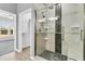 Bathroom featuring a glass enclosed walk-in shower with shower head, black mosaic tile accents, wood cabinets and an attached closet at 102 Harbor Point Ct, Summerville, SC 29486
