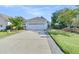 A house with a long concrete driveway leading to a two-car garage, a well-kept lawn, and mature landscaping at 102 Harbor Point Ct, Summerville, SC 29486