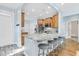 A view of kitchen island with seating and a light blue backsplash with light brown cabinetry and stainless steel appliances at 102 Harbor Point Ct, Summerville, SC 29486