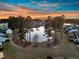 Stunning aerial view of a lake community at sunset, framed by tall trees and colorful sky at 105 Bluff Isle Ct, Summerville, SC 29486