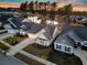 Scenic aerial view of a well-maintained neighborhood with homes surrounding a tranquil pond at sunset at 105 Bluff Isle Ct, Summerville, SC 29486