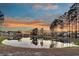 Picturesque lake view reflecting homes and a vibrant sky, surrounded by mature trees at 105 Bluff Isle Ct, Summerville, SC 29486