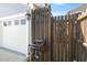 Exterior shot of a garage with a white door, wooden fence, and a neatly coiled garden hose on the side at 107 Nutmeg Way, Summerville, SC 29485