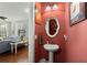 Stylish powder room with a pedestal sink, decorative mirror, and colorful walls at 107 Nutmeg Way, Summerville, SC 29485