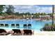Expansive swimming pool with lounge chairs, umbrellas, palm trees, and splash pad for community enjoyment at 107 Nutmeg Way, Summerville, SC 29485