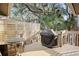 Cozy backyard deck with grill, table, and chairs surrounded by lush trees and greenery at 1153 Summerwind Ln, Seabrook Island, SC 29455