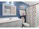 Charming bathroom with blue walls, a vanity, a framed mirror, and a shower with a decorative curtain at 1153 Summerwind Ln, Seabrook Island, SC 29455