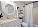 Bright bathroom with a white vanity, round mirror, decorative ladder, and shower with white curtain at 1153 Summerwind Ln, Seabrook Island, SC 29455