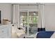 Bedroom featuring a cozy chair, white dresser with TV, and access to screened patio at 1153 Summerwind Ln, Seabrook Island, SC 29455