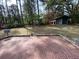 Spacious brick patio and a shed surrounded by lush greenery in this expansive backyard at 116 W Johnston St, Summerville, SC 29483