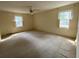A bedroom offers two windows, a ceiling fan, and neutral decor at 116 W Johnston St, Summerville, SC 29483