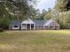 Charming brick home with mature trees, well-manicured lawn, and a welcoming front entrance with white columns at 116 W Johnston St, Summerville, SC 29483