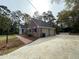 Spacious two-car garage with brick exterior, paved driveway, and lush landscaping, creating curb appeal at 116 W Johnston St, Summerville, SC 29483
