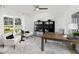 Bright home office featuring a ceiling fan, wood floors, and white wainscoting with large windows at 119 Royal Cainhoy Way, Huger, SC 29450