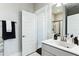 Neutral bathroom with a white sink, chrome hardware, vanity, large mirror, towel rack, and a door leading to the shower at 123 Hewitt St, Summerville, SC 29486